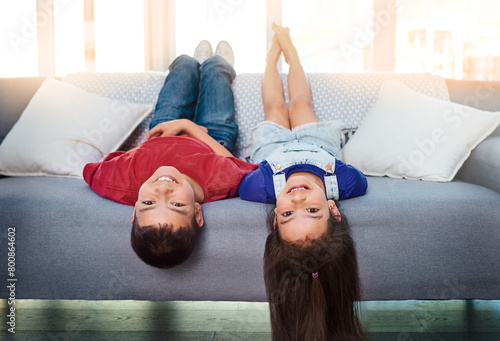Portrait, living room and upside down children on sofa for fun, game and playing. Kids, sofa and growth in healthy environment, joy and laughing with free time, active and cheerful at home