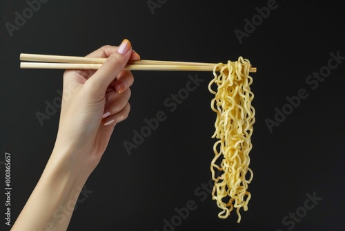 Creative mockup of woman holding Chinese chopsticks with instant noodles on black background