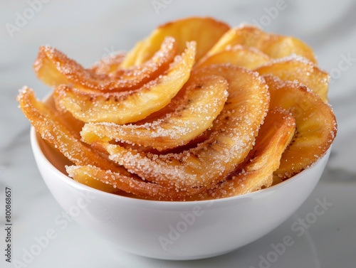 Freshly fried churros dusted with sugar, elegantly presented in a white ceramic bowl.