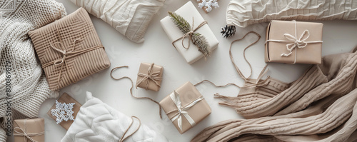 Flat lay of a cozy arrangement of gift boxes surrounded by plush blankets and pillows for a snug, comforting feel on a white background.