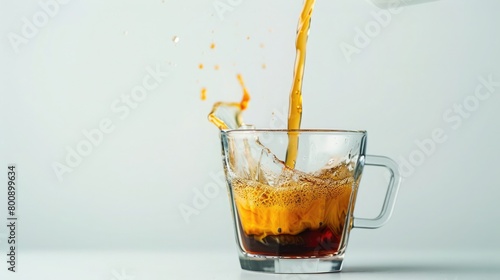 A glass cup pouring hot caffeine over white background