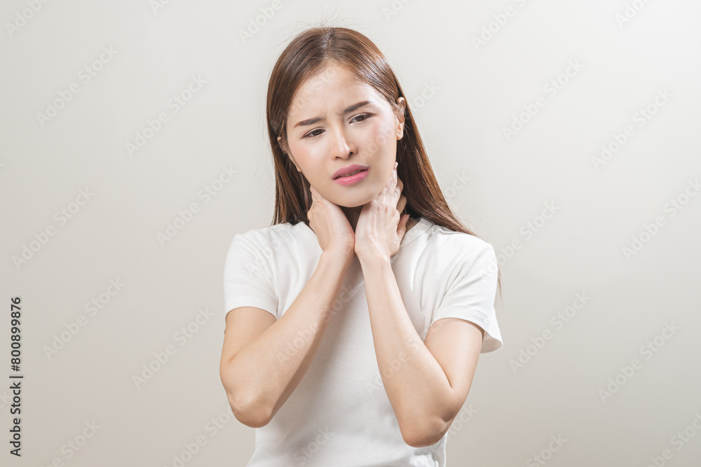 Sickness in inflaming asian young woman, girl use hand check self touch at sore throat, pain thyroid gland on neck or disease reflux, acid of suffer people on wall background. Medical and healthcare. Sickness in inflaming asian young woman, girl use hand check self touch at sore throat, pain thyroid gland on neck or disease reflux, acid of suffer people on wall background. Medical and healthcare.