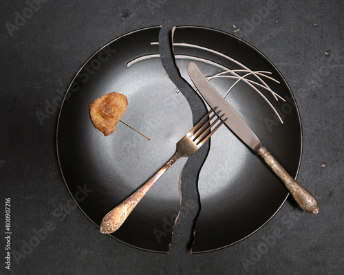autumn meal, dry leaf on the black broken plate, old silver cutlery