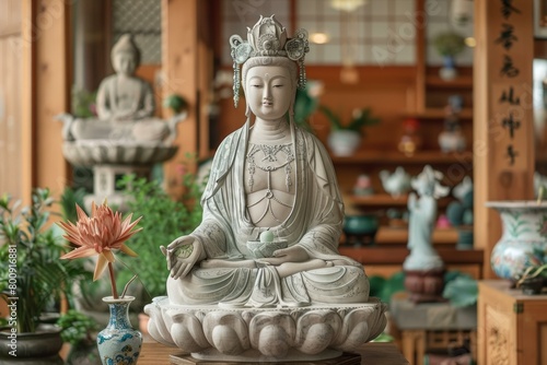 A ceramic statue of Avalokiteshvara  the bodhisattva of compassion  seated on a lotus pedestal  with a lotus flower in her left hand and a wish-fulfilling jewel in her right hand