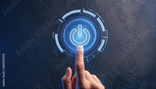 Close-up of a finger pressing a glowing blue power button on a dark background  photo