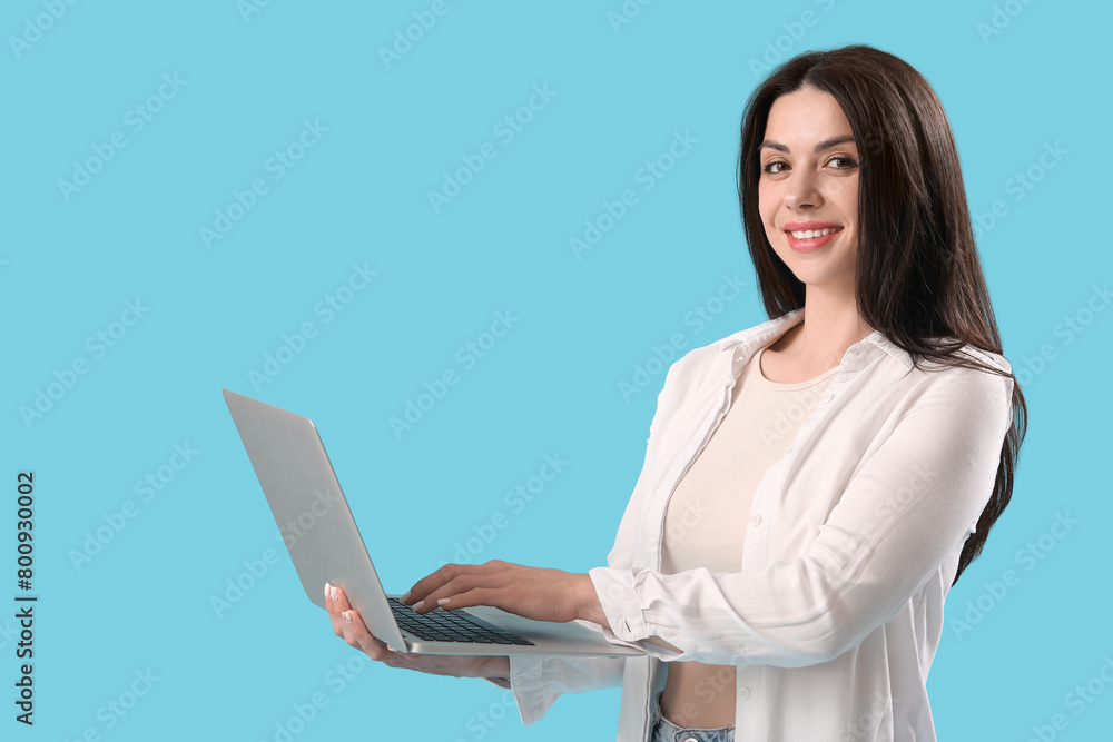 Female programmer working with laptop on blue background Female programmer working with laptop on blue background