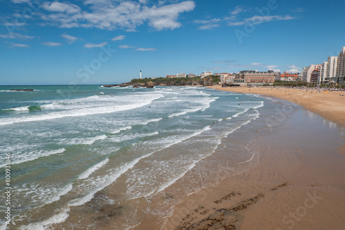 Praia em Biarritz com pequenas ondas e alguns banhistas e surfistas no mar num dia ensolarado photo