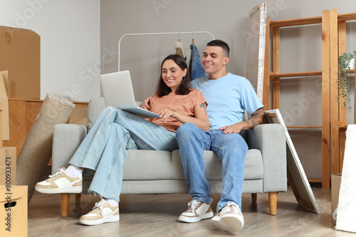 Happy young couple using la...