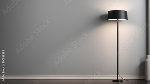 A black lamp is sitting on a wooden floor in front of a white wall