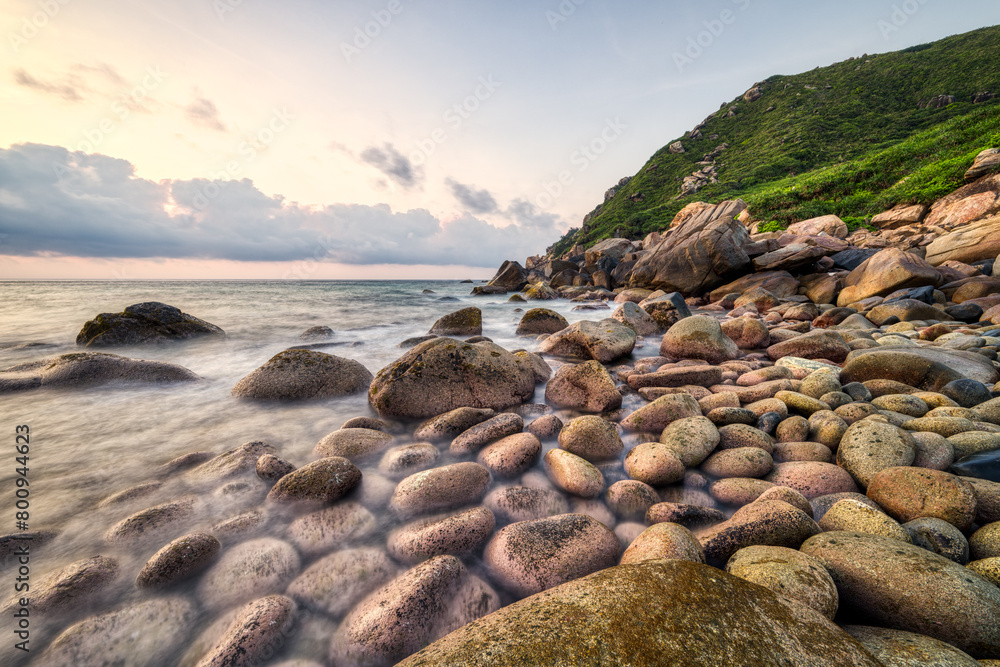 Sunrise sea view on pebble beach. Location: Wanning, Hainan, China.