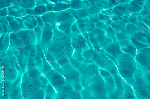 Water in pool with sun reflection. Photography reflection of sun rays on the bottom of the pool..Water surface background  texture.