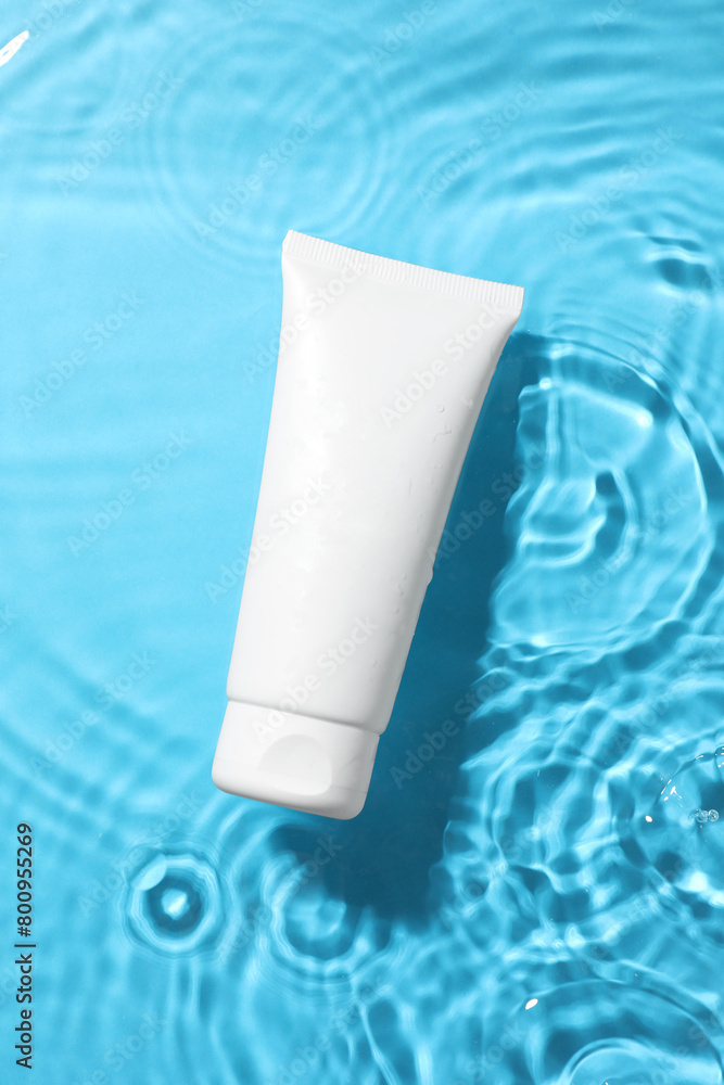 Tube with moisturizing cream in water on light blue background, top view Tube with moisturizing cream in water on light blue background, top view