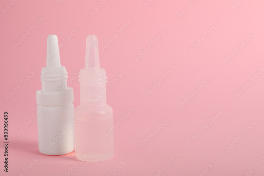 Bottles of medical drops on pink background, space for text Bottles of medical drops on pink background, space for text