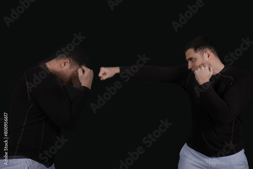 Young man in motion practicing his punch on black background