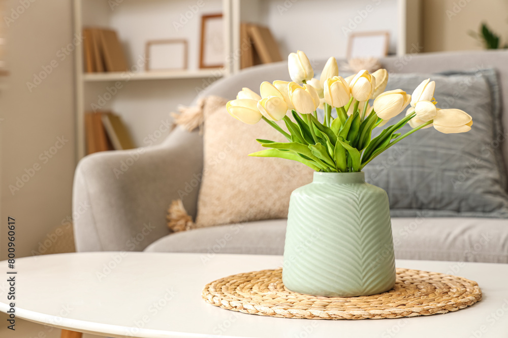 Coffee table with vase of tulips in stylish living room