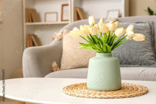 Coffee table with vase of tulips in stylish living room