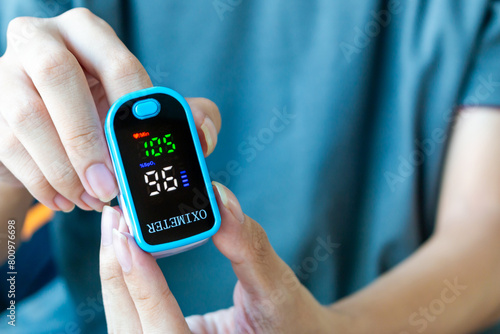 oxygen meter, Patients use fingertip oximeter, measuring oxygen levels as basic health check.