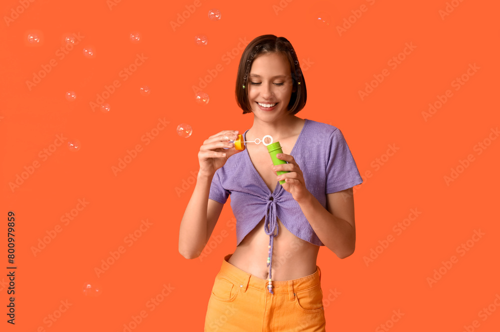 Teenage girl with soap bubbles on orange background Teenage girl with soap bubbles on orange background