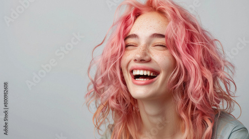 A woman with pink hair is smiling and laughing