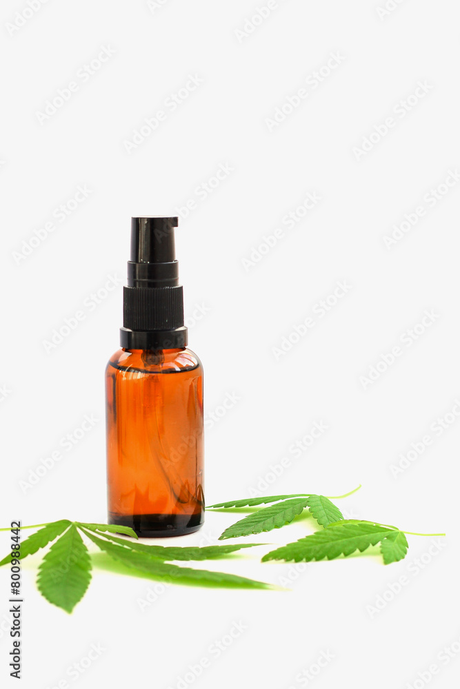 Marijuana leaves and a bottle on a white background, cannabis cosmetic oil Marijuana leaves and a bottle on a white background, cannabis cosmetic oil