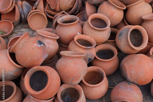 pots are gathered and arranged in a pattern in the empty space. The potter works on a pottery wheel to made of soft colored clay, retro style toned Clay pots with hand and equipment