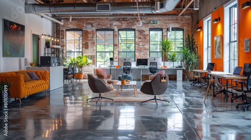 Unoccupied work environment with exposed ceiling, polished concrete floor, task table with computers for eight, paned windows, and colorful furnishings. photo