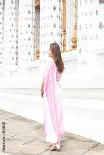 Tourist Asian woman wearing Thai national costume comes to visit an old church Thailand.