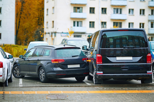 Obraz na płótnie Car accident in tight parking lot, black sedan hitting parked van while backing up, reverse parking. Parking accident due to limited visibility, distracted driving. Rear-up collision. Minor accident w salonie