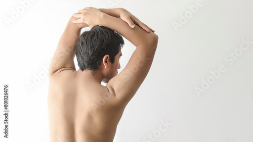 Naked man back, lifting his arms, looking to the right, white background, with space for text, styling