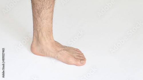 Adult man foot against white background with space for text, view of inner ankle © juanjomenta