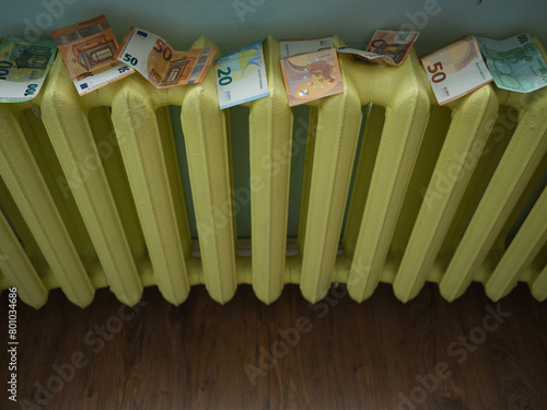 Money laundering concept image with copyspace. Euro banknotes drying on yellow radiator.