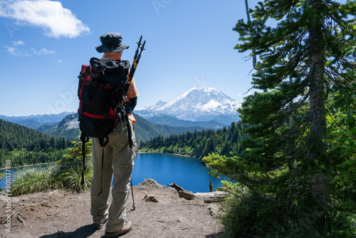 Backpacker enjoying the views of beautiful Summit lake and Mount Rainier. Mt Rainier National Park. Washington State. USA.