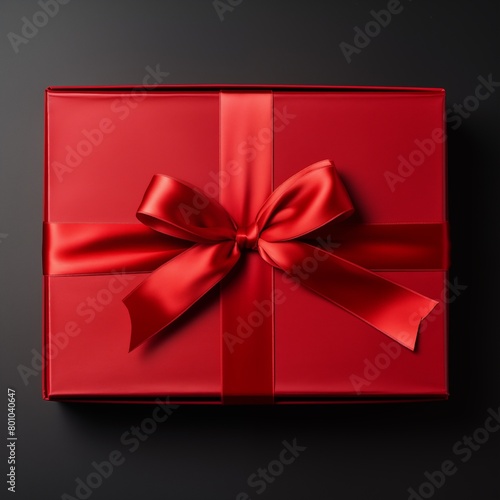 Elegant Red Gift Box with Satin Ribbon Tied in a Bow on a Black Background