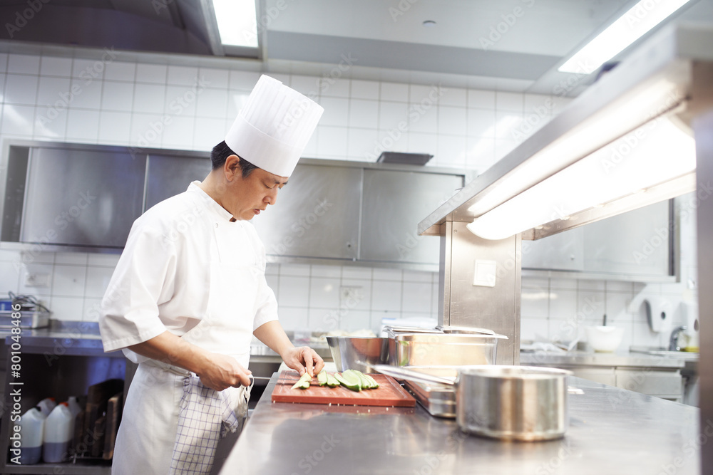 Chef, man and knife in kitchen for food industry, catering service or prepare dish. Hospitality, professional and asian person cutting for cooking meal, fine dining or dinner in restaurant in China Chef, man and knife in kitchen for food industry, catering service or prepare dish. Hospitality, professional and asian person cutting for cooking meal, fine dining or dinner in restaurant in China