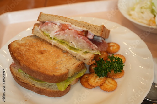 Delicious Prosciutto Ham or Dry-Cured Ham Sandwich made of Toasted Bread, Ham and Lettuce on plate - 生ハム サンドウィッチ 