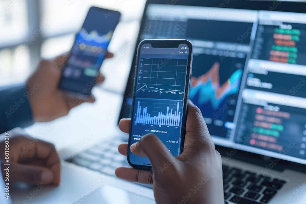 business, technology, internet and people concept - close up of man with laptop computer and smartphone with stock market chart on screen over office background business, technology, internet and people concept - close up of man with laptop computer and smartphone with stock market chart on screen over office background