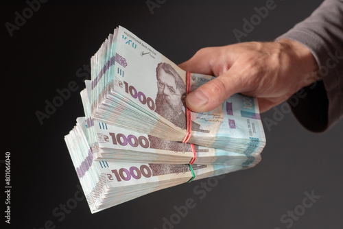 Man holding Ukrainian money 1000 hryvnia banknotes. closeup