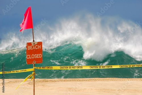 A sign at Waimea Bay on Oahu warning that the beach is closed due to high surf.