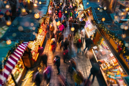 Busy crowd of people walking down a city street at night, with shops and vendors lit up for Christmas