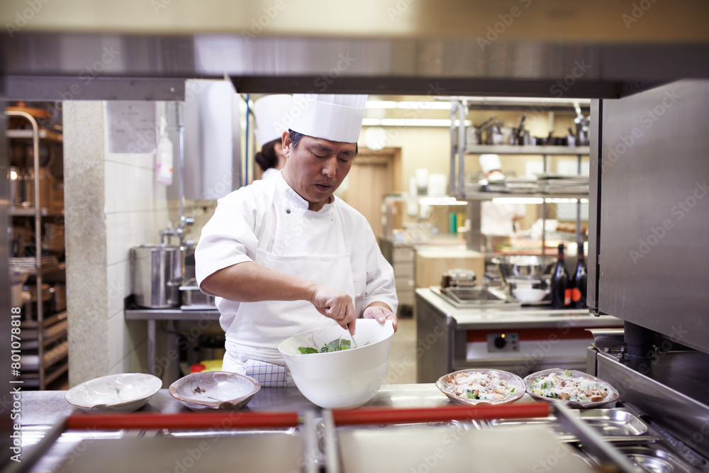 Asian man, chef and food service for restaurant with catering industry, uniform and fine dining for nutrition. Male employee, hospitality and cuisine in kitchen for menu, cooking career and dinner Asian man, chef and food service for restaurant with catering industry, uniform and fine dining for nutrition. Male employee, hospitality and cuisine in kitchen for menu, cooking career and dinner