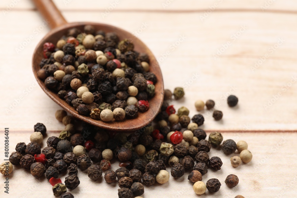 Aromatic spices. Different peppers in spoon on wooden table, closeup Aromatic spices. Different peppers in spoon on wooden table, closeup