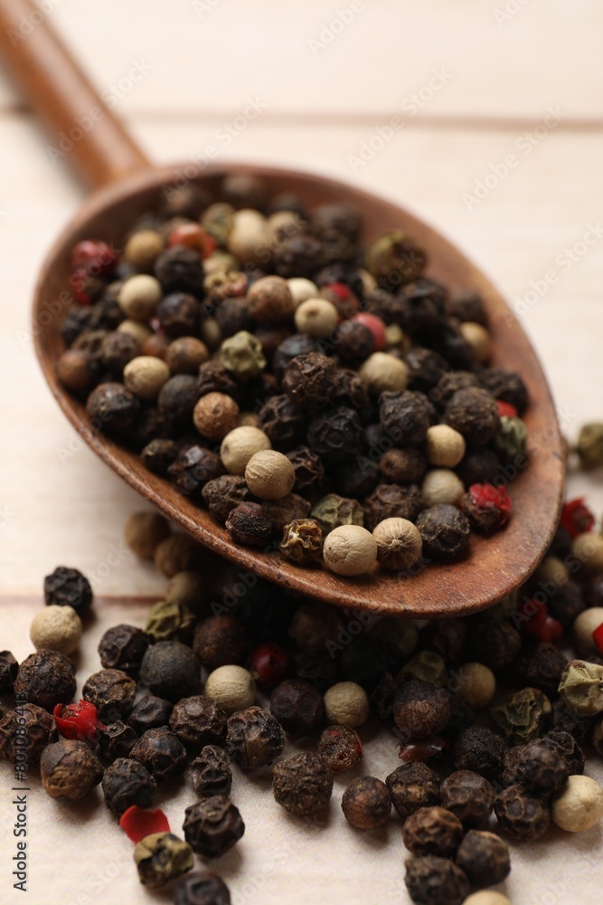 Aromatic spices. Different peppers in spoon on wooden table, closeup Aromatic spices. Different peppers in spoon on wooden table, closeup