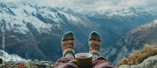 portrait of woman's legs relaxing with mountain view with cup of hot drink.