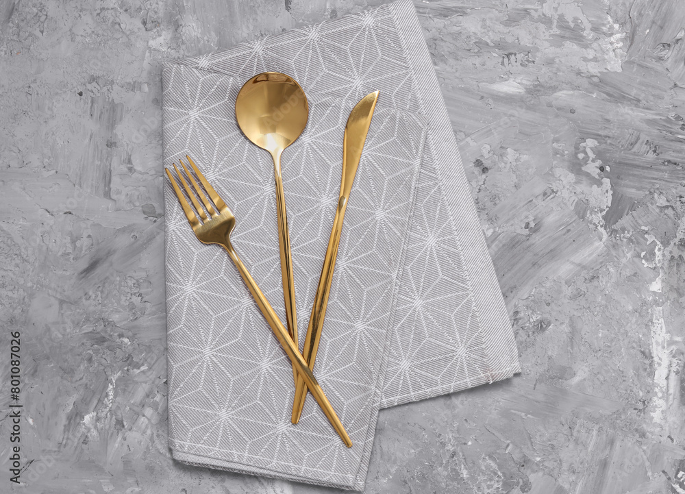 Obraz premium Beautiful cutlery set and kitchen towel on grey table, top view