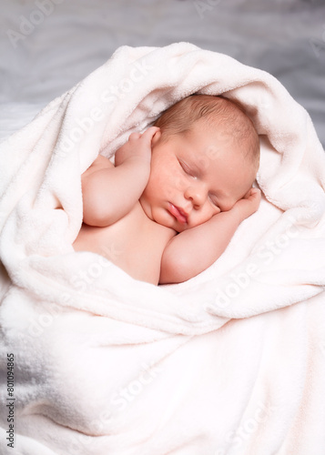 A newborn baby peacefully sleeping on a soft white blanket
