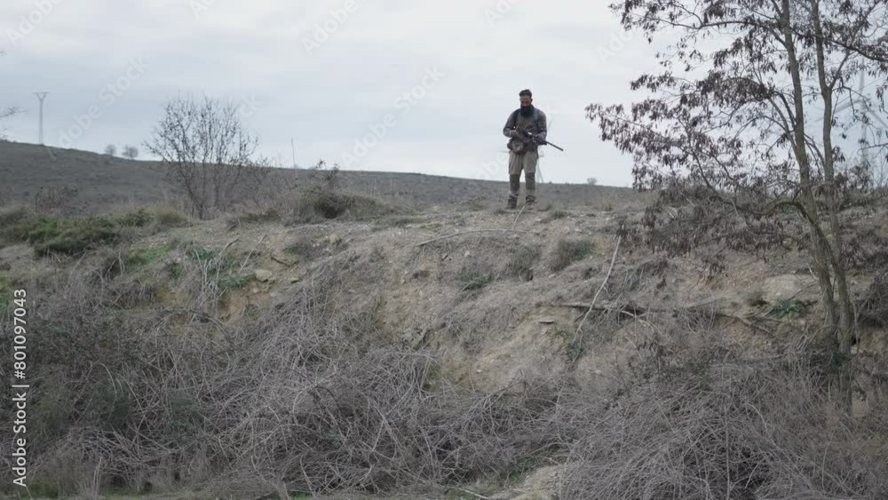 A dog looking for something on the ground and a hunter A dog looking for something on the ground and a hunter