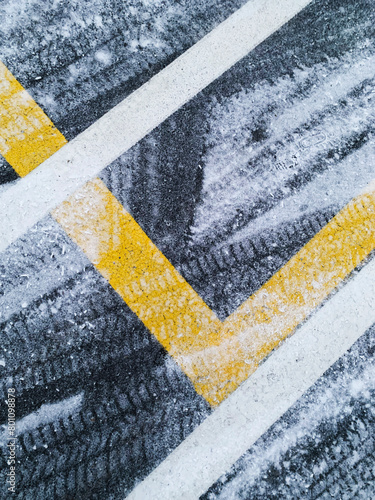 Snowflakes on grey street with yellow land white lines, street with space for text, no person
