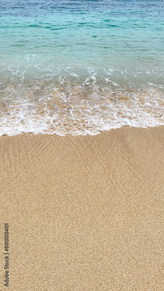 a close up of a wave crashing onto a sandy beach. a close up of a wave crashing onto a sandy beach.