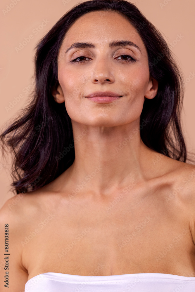 Studio portrait of a charming brunette woman in a white top with beautiful wavy hair Studio portrait of a charming brunette woman in a white top with beautiful wavy hair