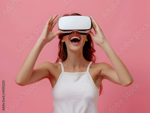 Portrait of happy young brunette woman wearing white augmented virtual reality glasses on pink color studio background with copy space